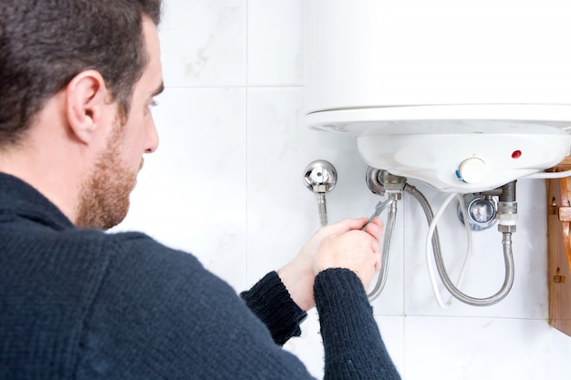 Photo plumber fixing electric water heater