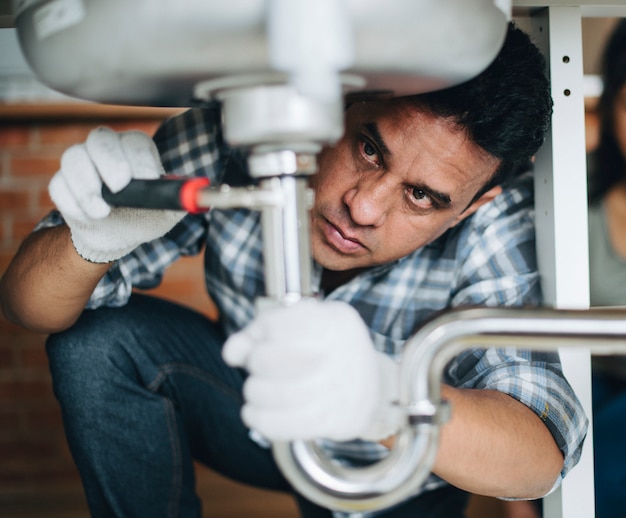 Plumber fixing the kitchen sink