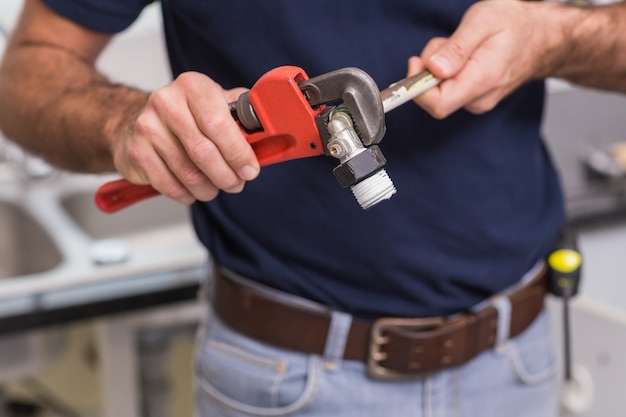 Plumber fixing pipe with wrench