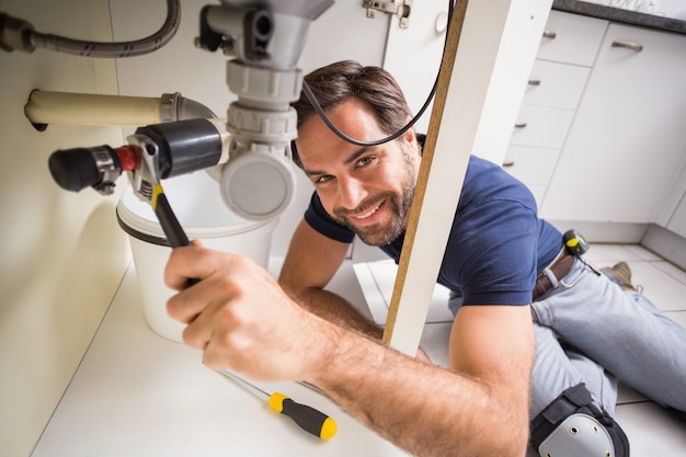 Photo plumber fixing under the sink