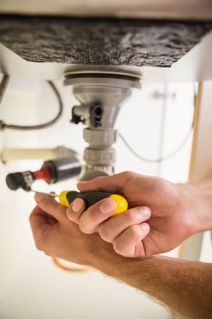 Plumber fixing under the sink