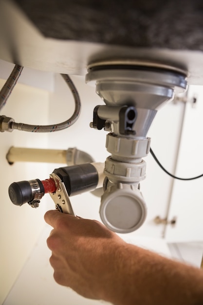 Plumber fixing under the sink