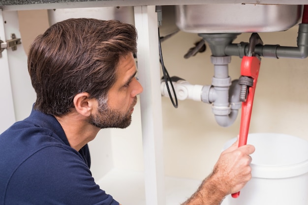 Plumber fixing under the sink