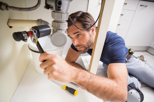 Photo plumber fixing under the sink