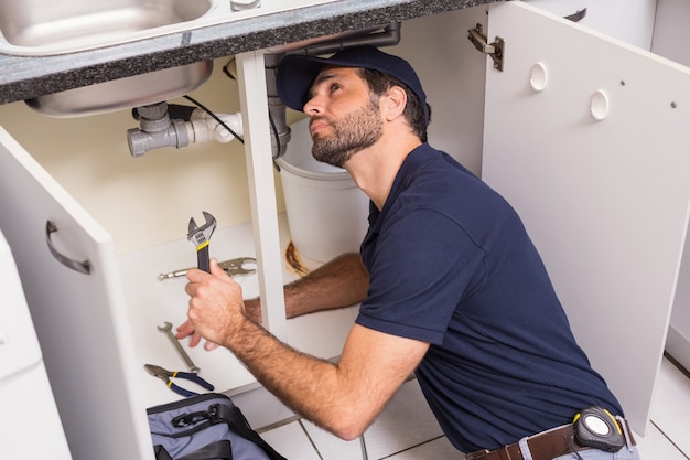 Plumber fixing under the sink