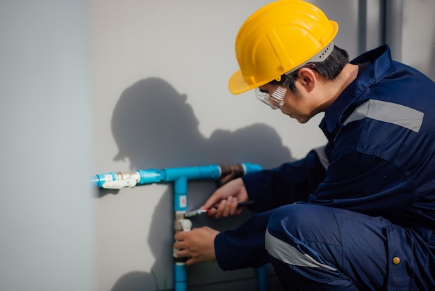 A plumber is fixing the leaked pipe outdoors