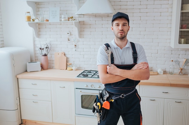 Plumber in the kitchen with tools belt