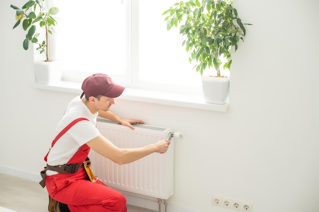 Plumber man is blocking repairs radiators of heating battery in
apartment tap.