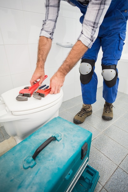 Plumber putting his tools on toilet