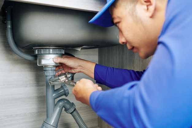 Plumber repairing a leaky drain