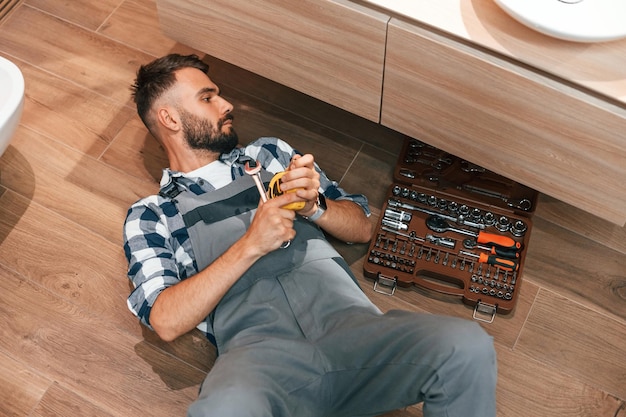 Plumber in uniform is indoors at home