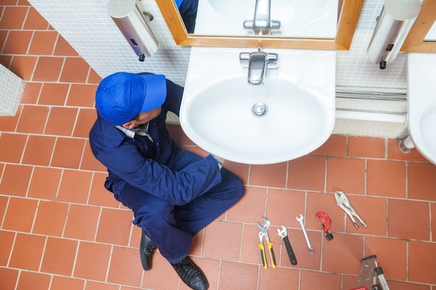 Photo plumber with cap repairing sink