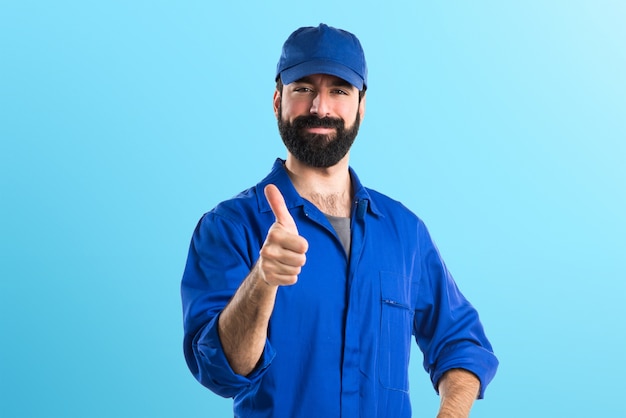 Plumber with thumb up on colorful background