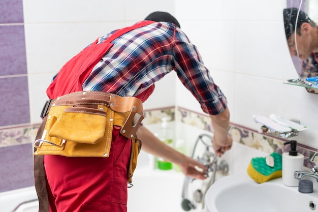 Photo plumber at work in a bathroom plumbing repair service assemble and install concept