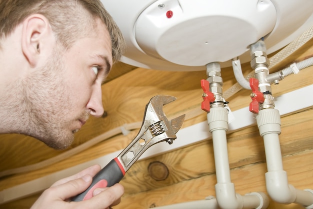 Plumber at work. Servicing gas boiler