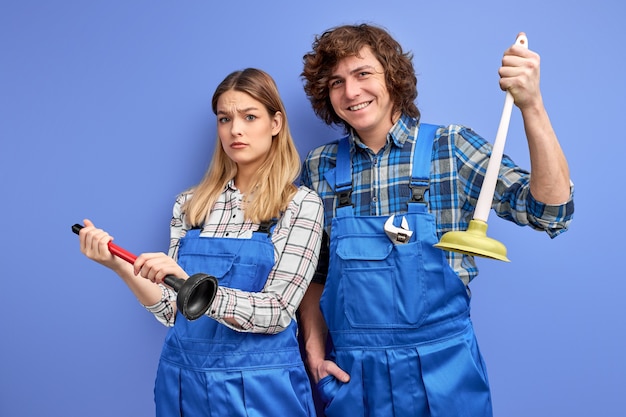 plumbers holding plunger in hands, ready to repair sink and bathroom