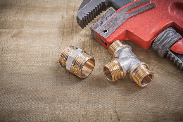 Plumbers wrench plumbing fixtures on mesh filter grid.