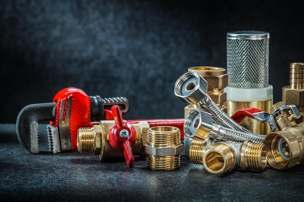 Plumbing brass pipe connectors on dark background