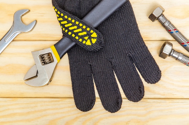 配管設備の修理工具、モンキーレンチ、手袋、木の板の柔軟な接続