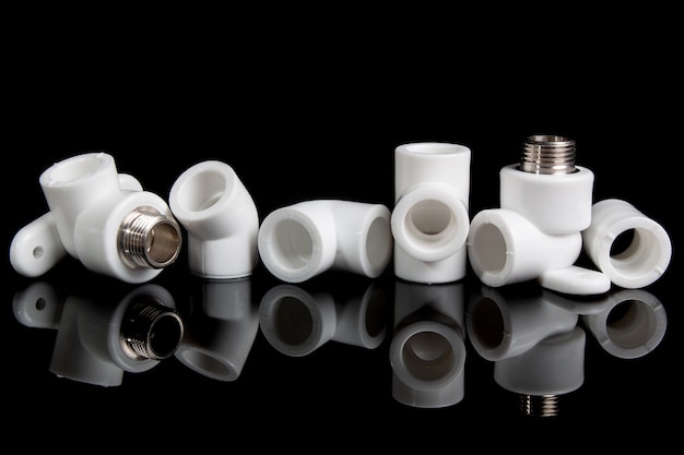 Plumbing fittings for plastic pvc pipes on black background