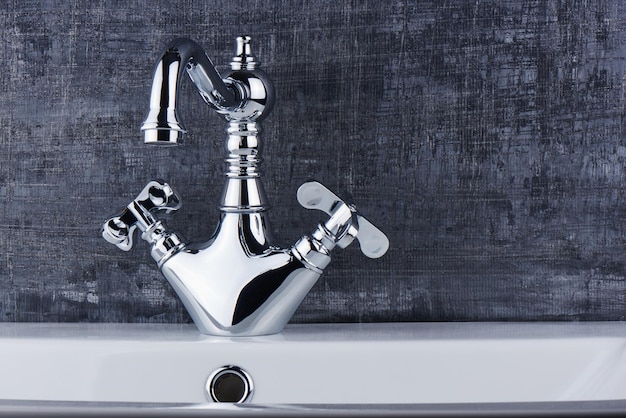 Plumbing. The interior of the bathroom. Faucet sink on black and white background.