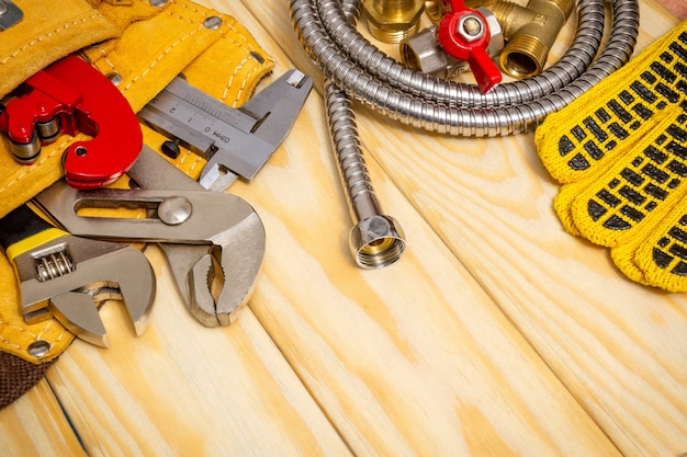 Plumbing tool in the bag and hose on wooden boards