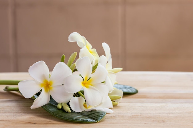 Plumeria flowers on wooden table and grunge texture backgrounds