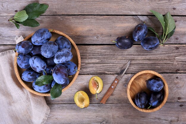 Plums in a bowl on a wooden table