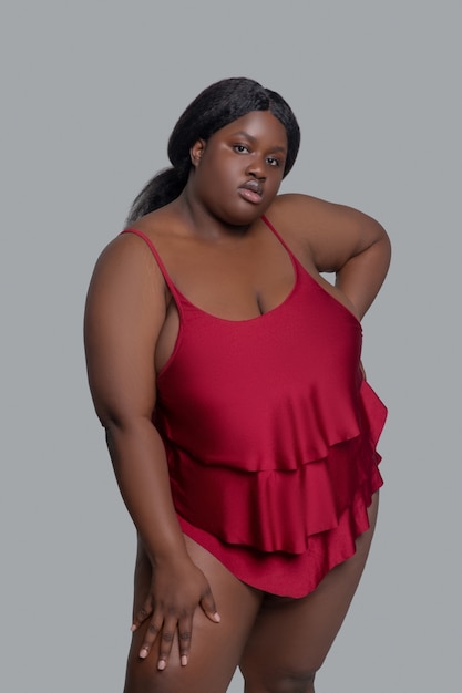 Plus grootte Afro-Amerikaanse jonge vrouw in rood ondergoed poseren