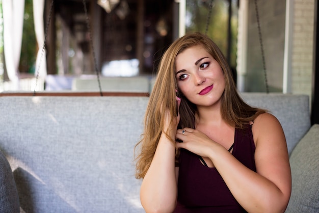 Plus size beautiful young woman with tablet and phone in a restaurant.