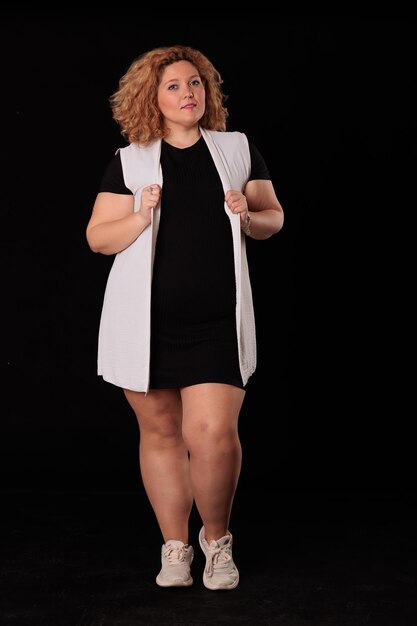 Photo plus size blonde woman in photo studio on black background curvy woman