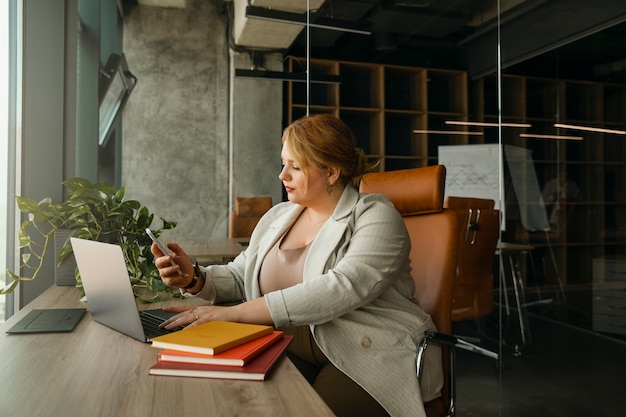 Photo plus-size business woman working in a professional office