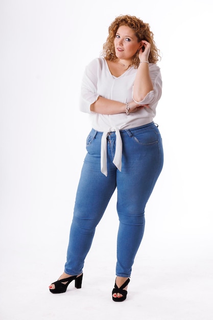 Plus size fashion model fat woman in denim clothes and white shirt on white background overweight female body