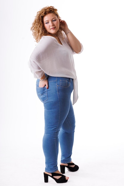 Plus size fashion model fat woman in denim clothes and white shirt on white background overweight female body