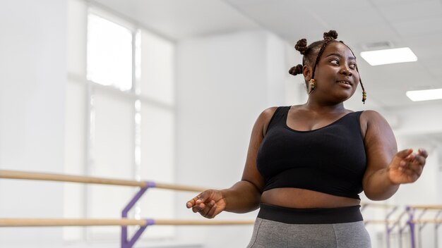 Photo plus-size female ballerina in the studio