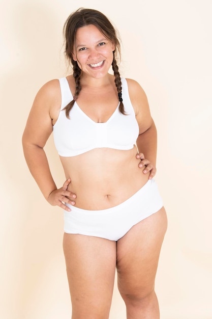 Plus size girl in lingerie with two braids smiling and showing off her body proud of her body