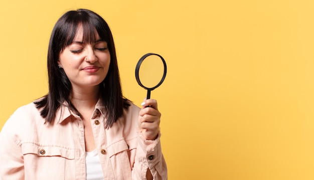 Plus size mooie vrouw kijkt met een vergrootglas