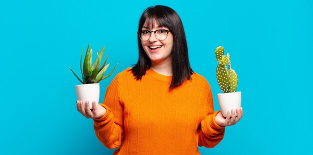 Photo plus size pretty woman holding cactus. aloe vera concept