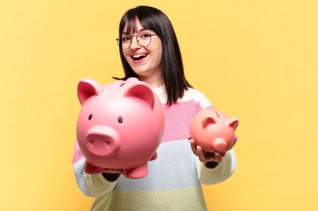 Plus size pretty woman with a piggy bank. savings concept