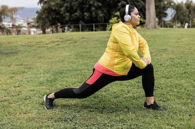 Plus size vrouw doet sport workout routine buiten in stadspark
