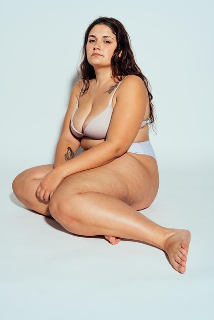 Plus size vrouw poseren in studio in lingerie
