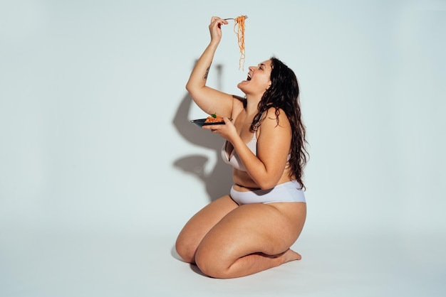 Plus size vrouw poseren in studio in lingerie