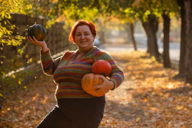 Plus size vrouwenportret met pompoenen buiten