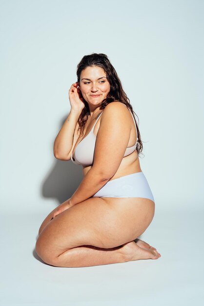 Plus size woman posing in studio in lingerie