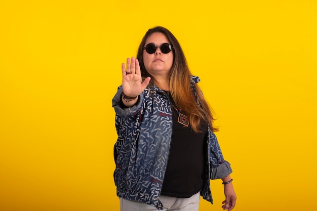 Plus size woman in stylish clothes in studio photos with facial expressions