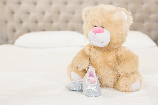 Plush and infant shoes on bed