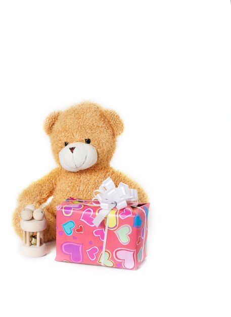 Plush teddy bear with presents on gray background. Closeup