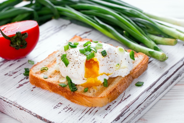 Poached egg on toast on a wooden case background