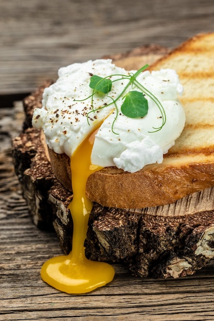 Poached egg on toast on the wooden table Healthy food keto diet diet lunch concept vertical image top view place for text