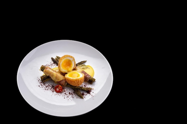 Poached egg with asparagus isolated on black